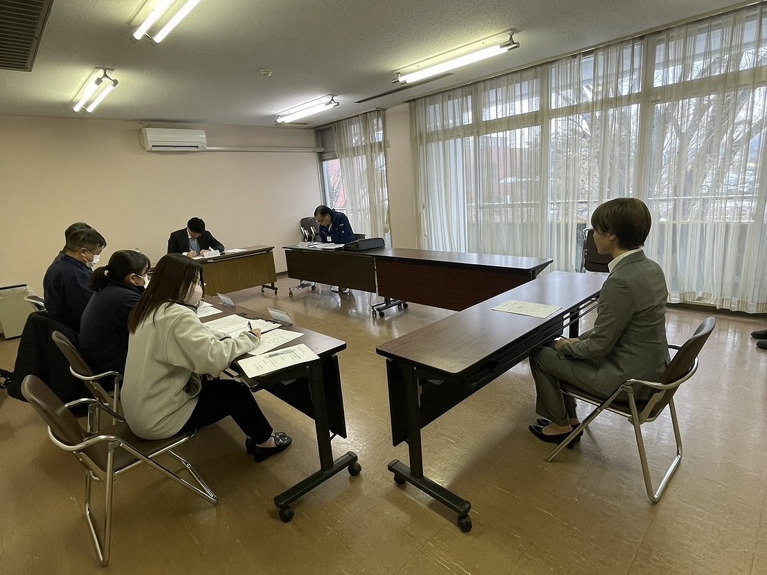 数名の審査員の前で審査を受けている女性研修生