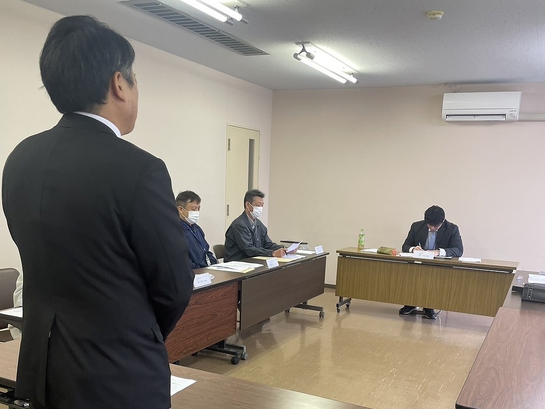 数名の審査員の前で審査を受けている男性研修生