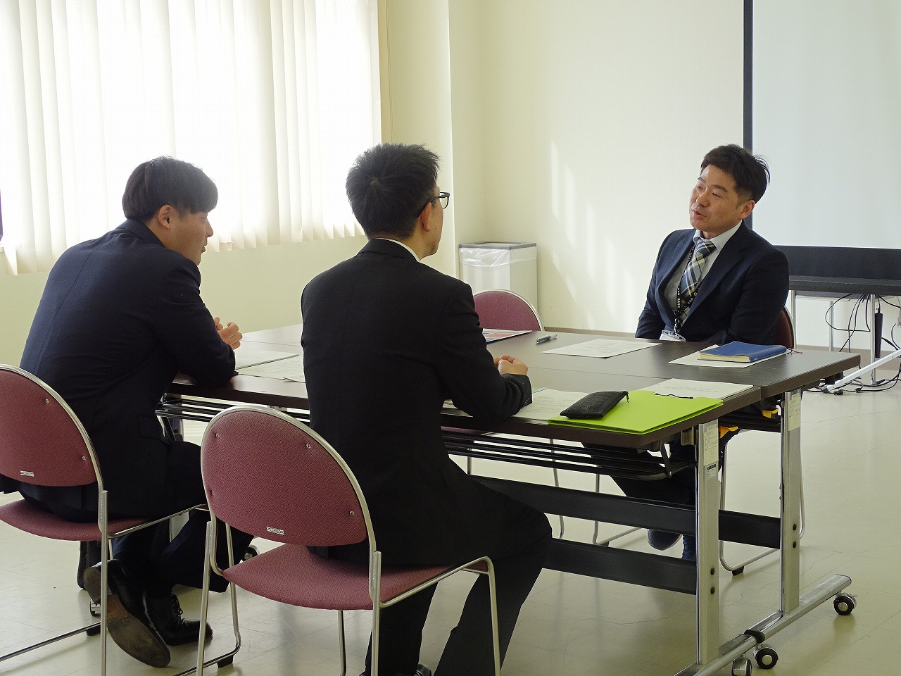 オリエンテーションの様子(担当者から今後の流れなどの説明を受ける新入生2人)