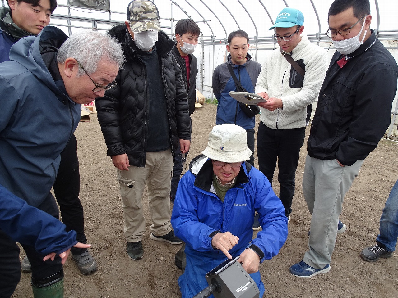 研修施設7号ハウスで硬度計を使用し土壌の硬度を調査している様子