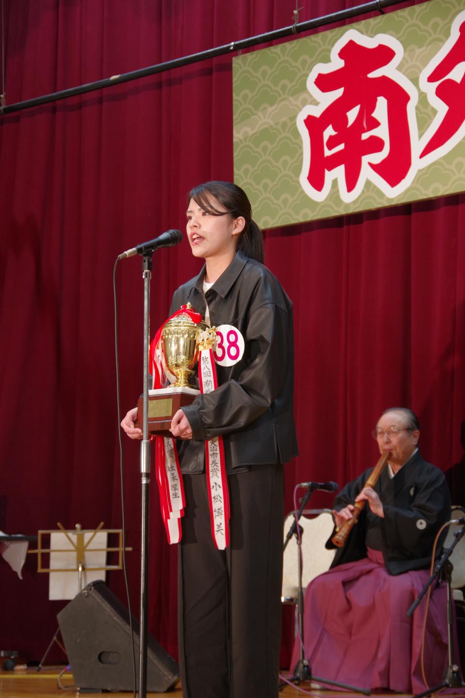優勝トロフィーを持ちながら唄う嵯峨さん