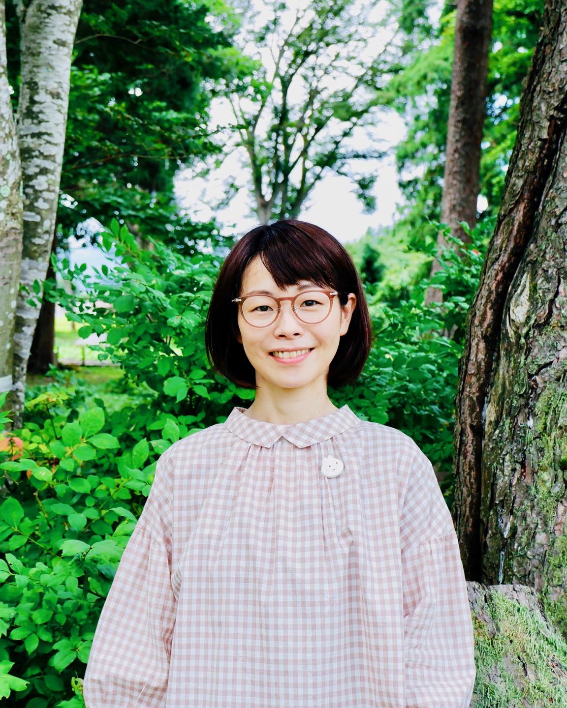 緑の自然に囲まれて笑顔でたたずむ藤嶋さん