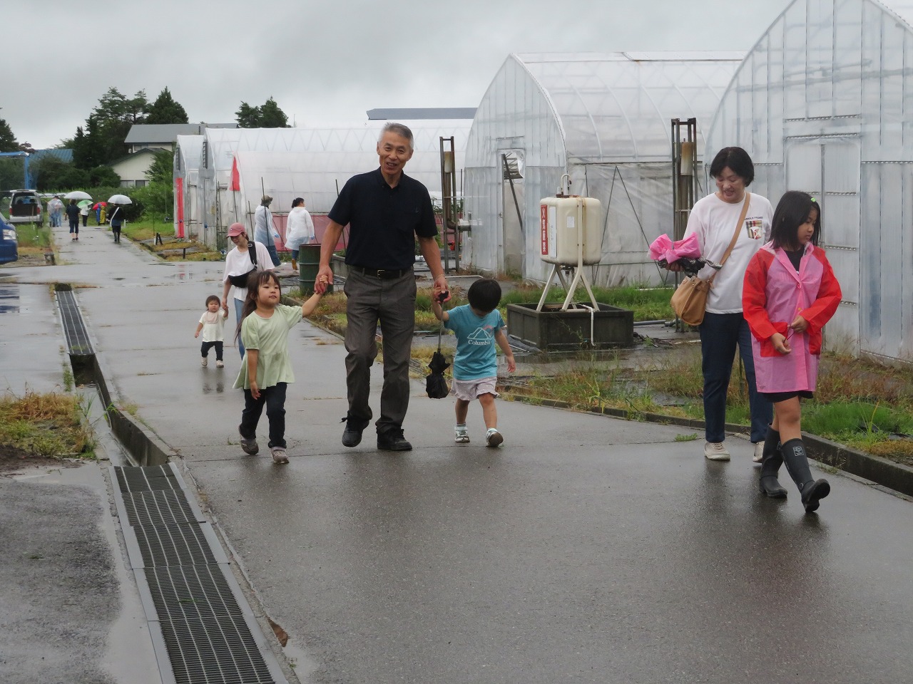 参加者の様子、孫2人と手をつないで施設ないを見学するおじいさん