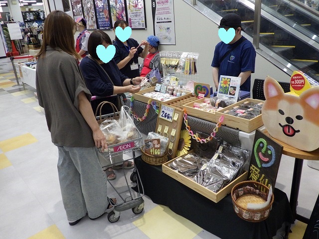 愛仙(あいせん)の販売ブース、お客様が商品を手に取り品定めしている