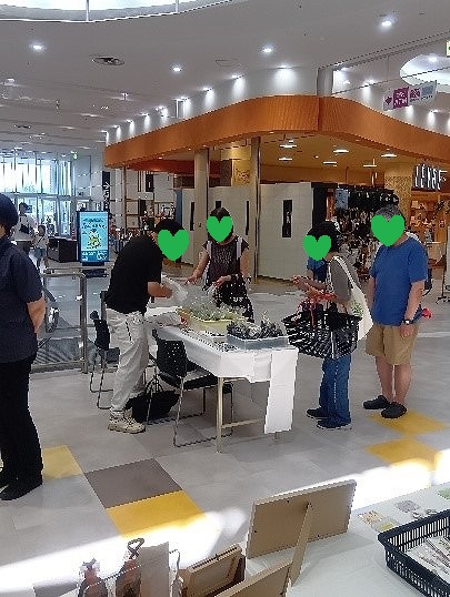 湧遊家の販売ブース、お客様が野菜を選んでいる