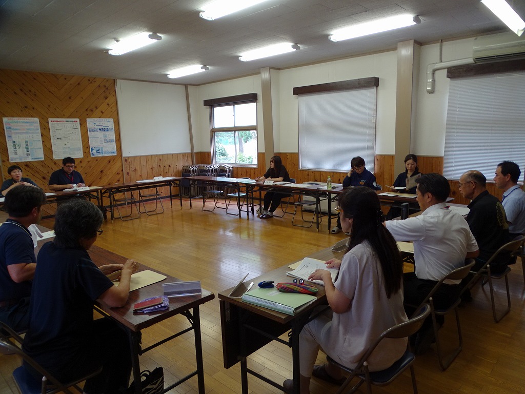情報交換会の様子、テーブルを囲み概要の説明や意見を述べている